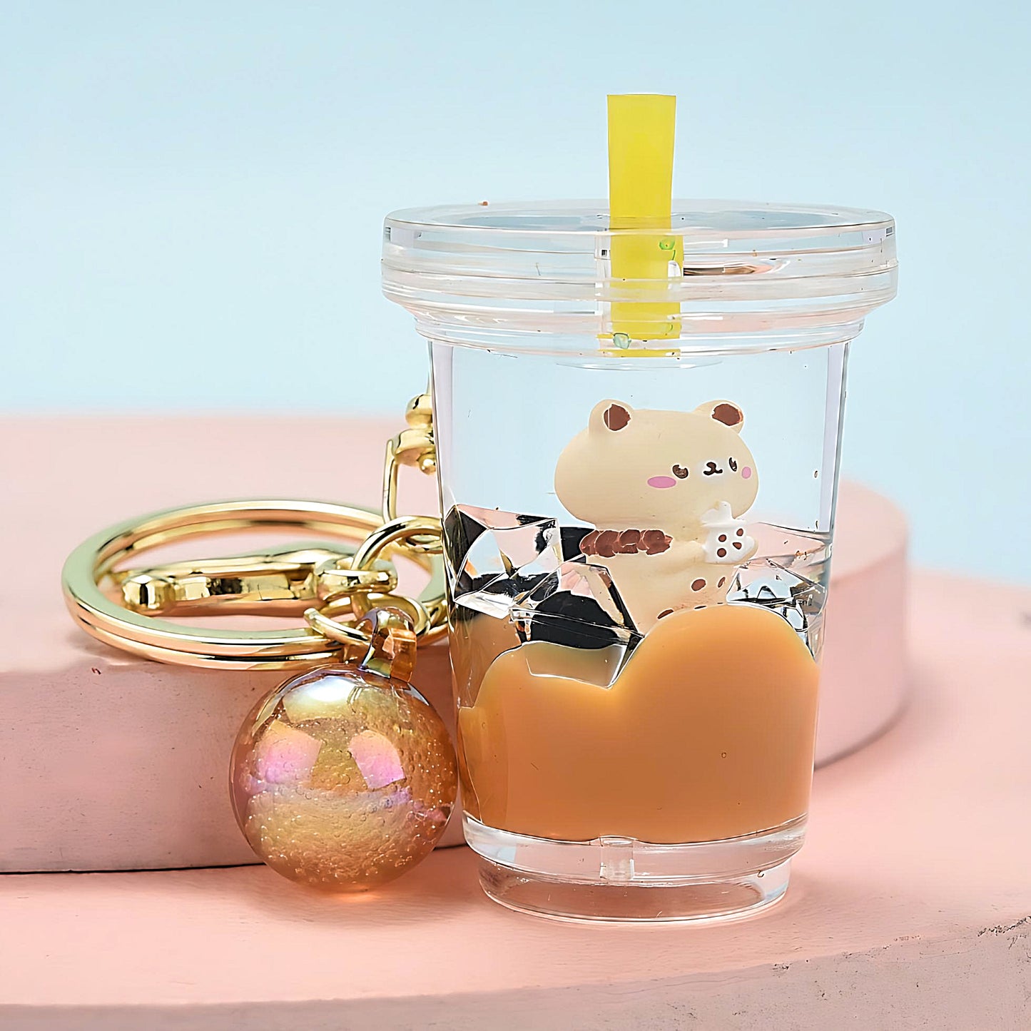 a Bubble Tea keychain on a pink display, blue background
