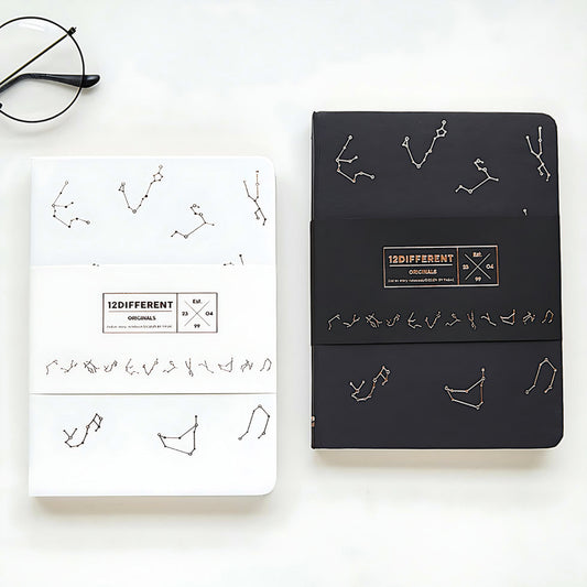 two Constellation notebooks, one white, one black, on a white background