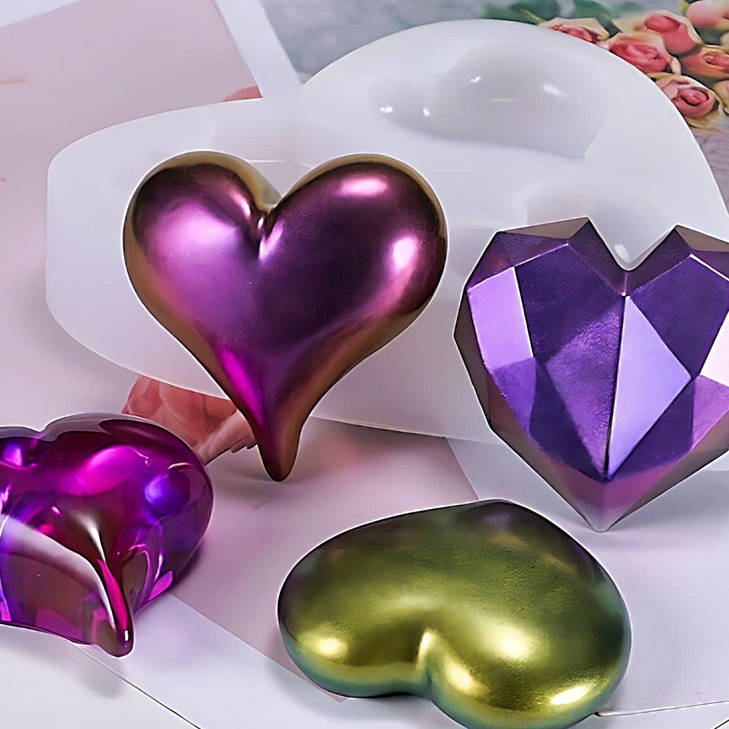 an heart-shaped silicone mold with four heart ornaments beside a magazine with roses on it