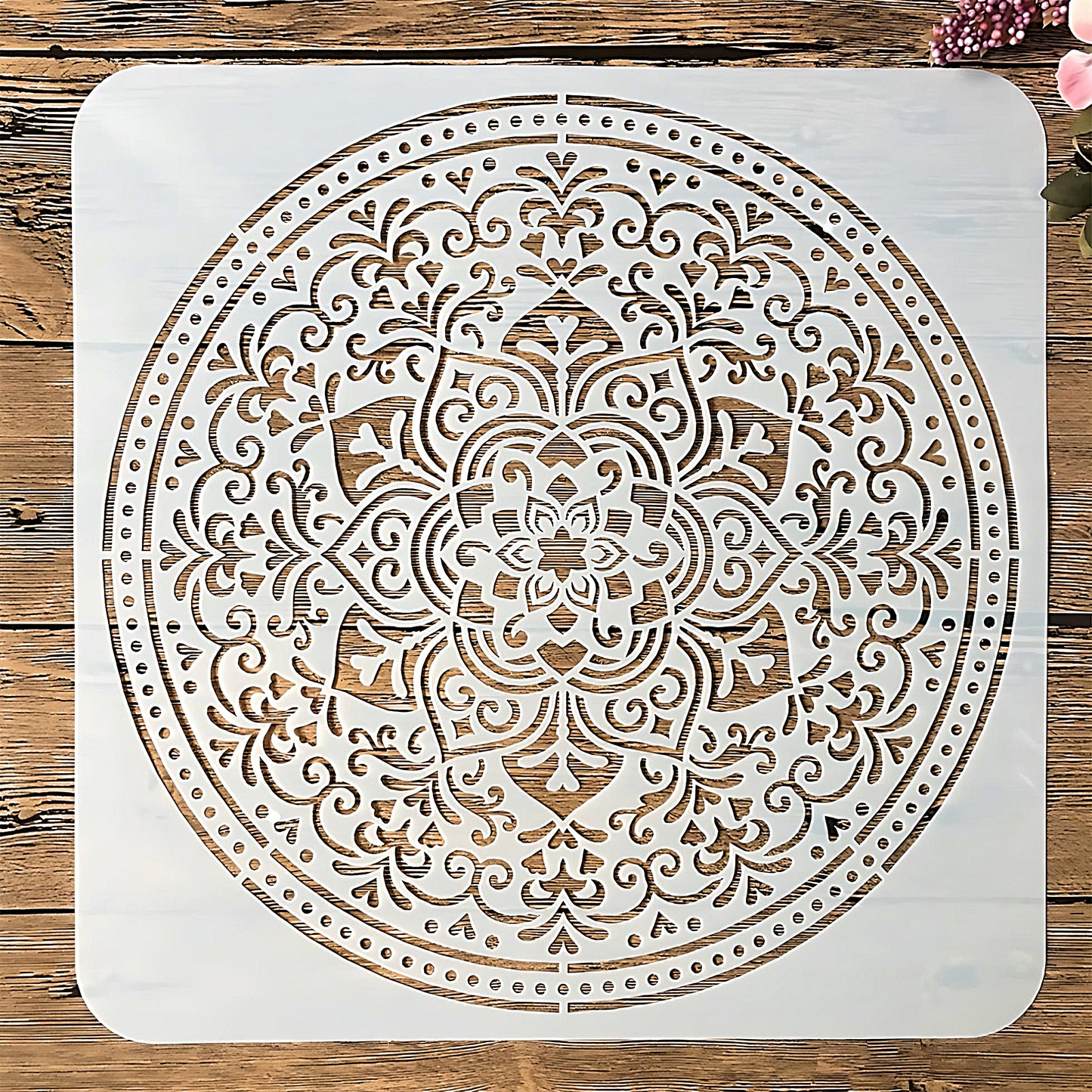 a large Mandala stencil in white color, on a wood table