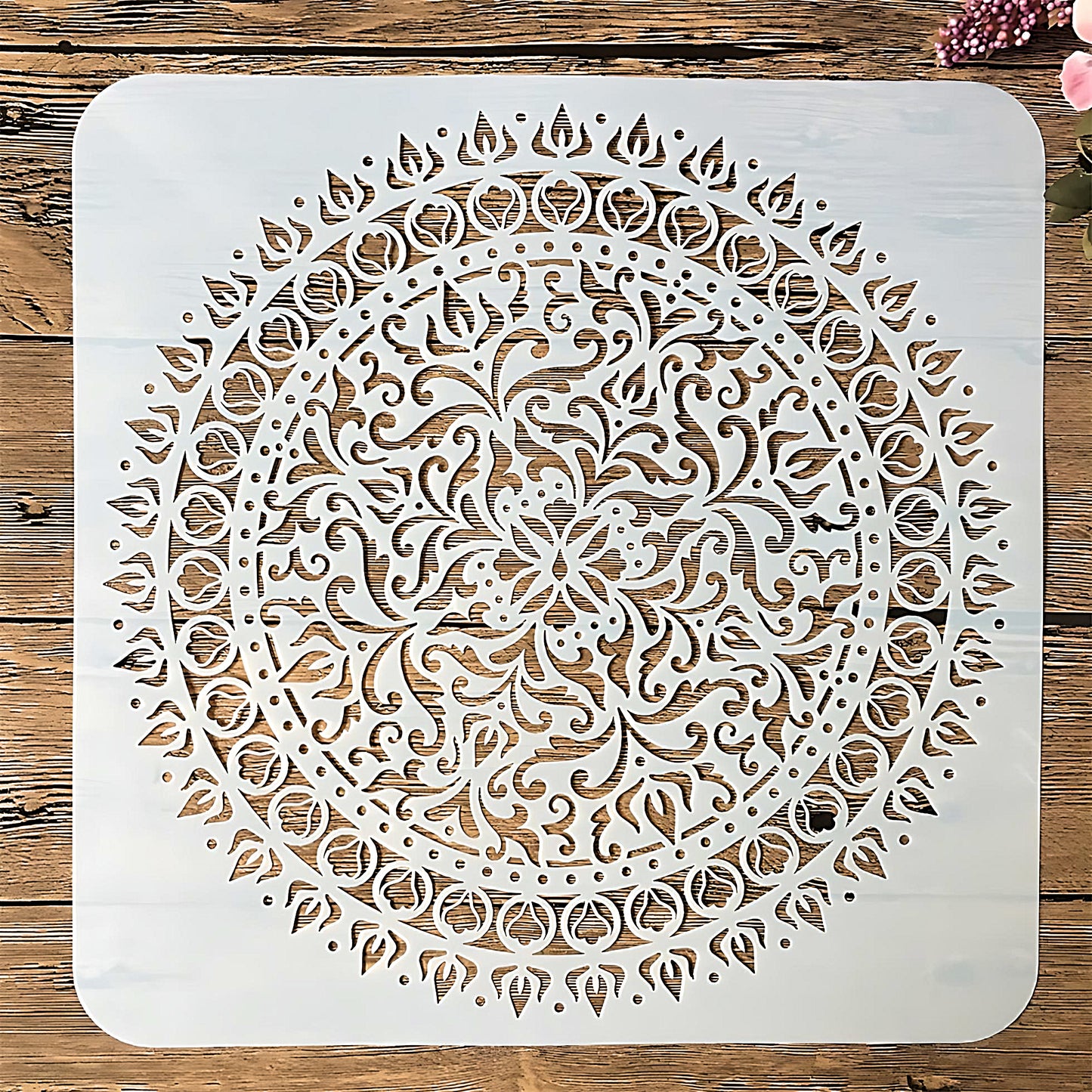 a large Mandala stencil in white color, on a wood table