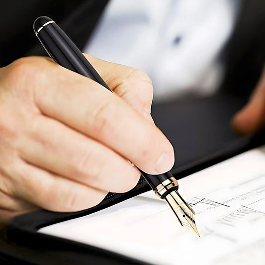 a man signing a document with a Montagut Fountain Pen