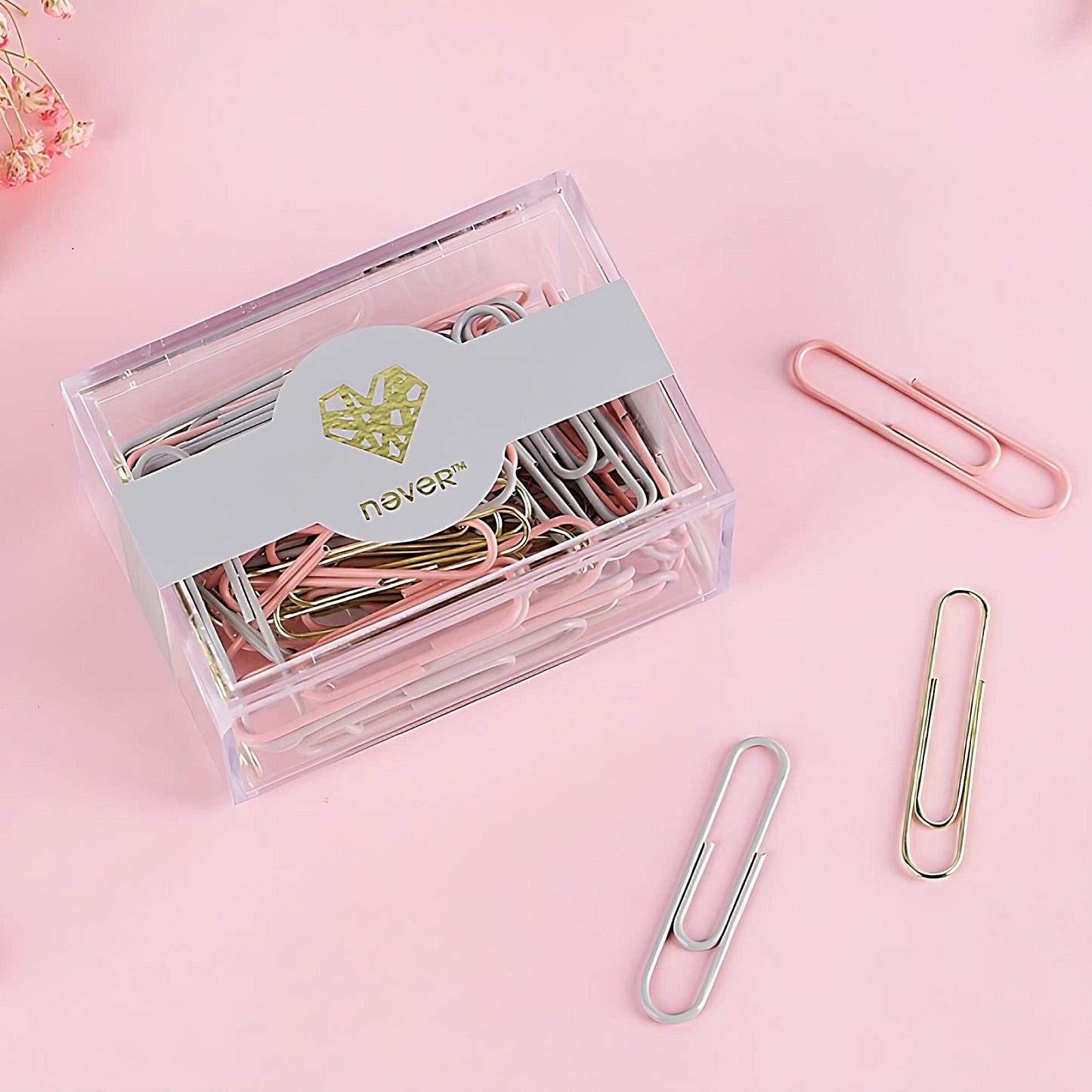 a box full of pink, grey and gold paper clips