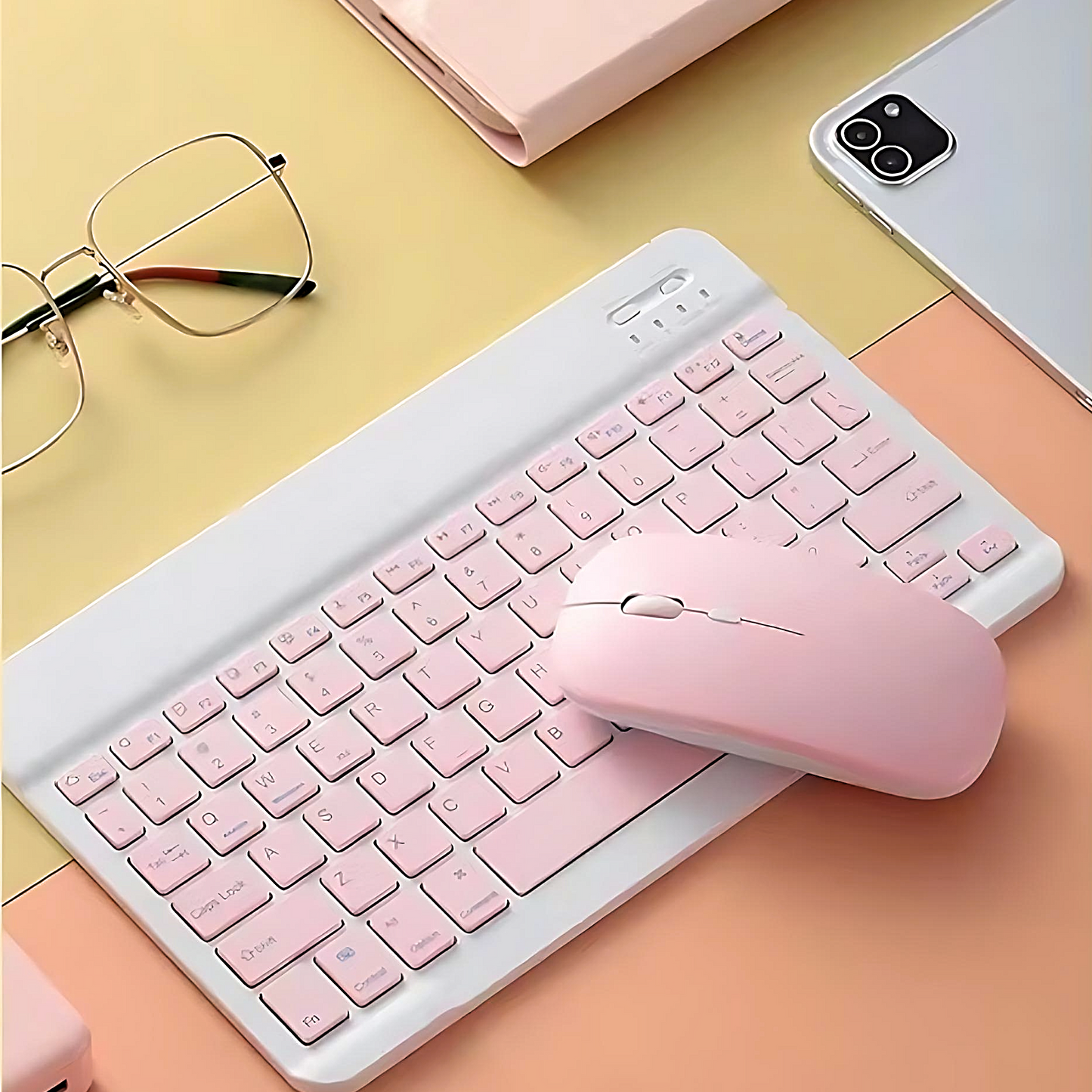 a pastel wireless keyboard and mouse set on a yellow and orange background