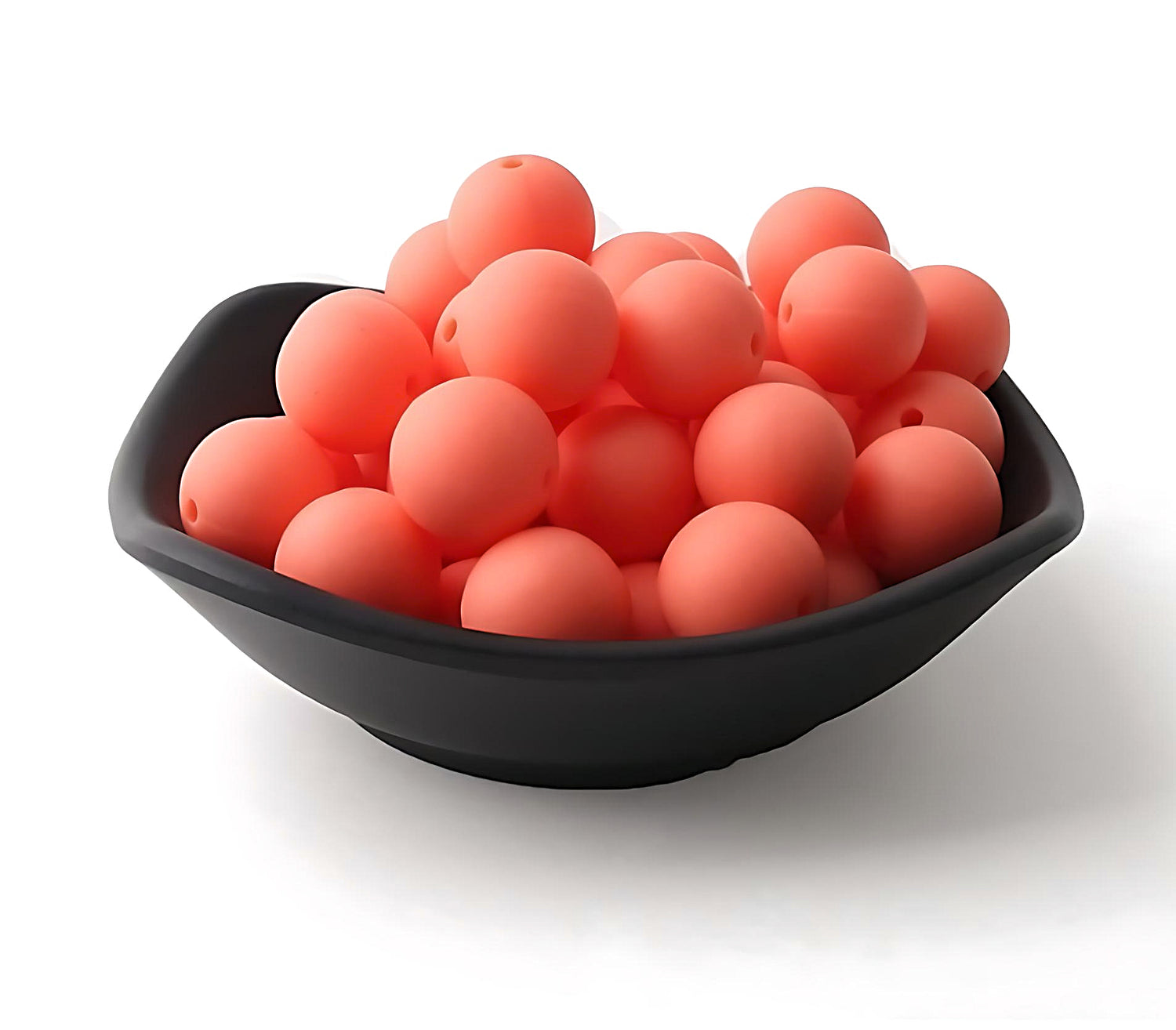 orange silicone beads in a black bowl