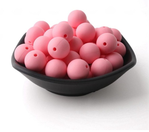 pink silicone beads in a black bowl