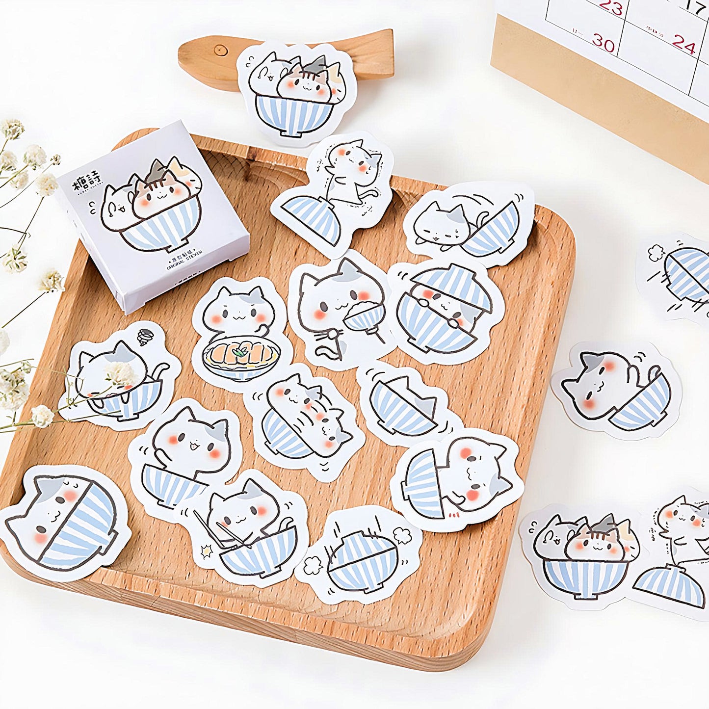 some Sushi Cat stickers on a wooden plate