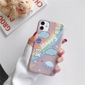 a woman holding an iPhone case with a Kawaii bear and rainbow design on it