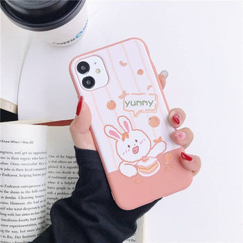 a woman holding an iPhone case with a Kawaii bunny design on it